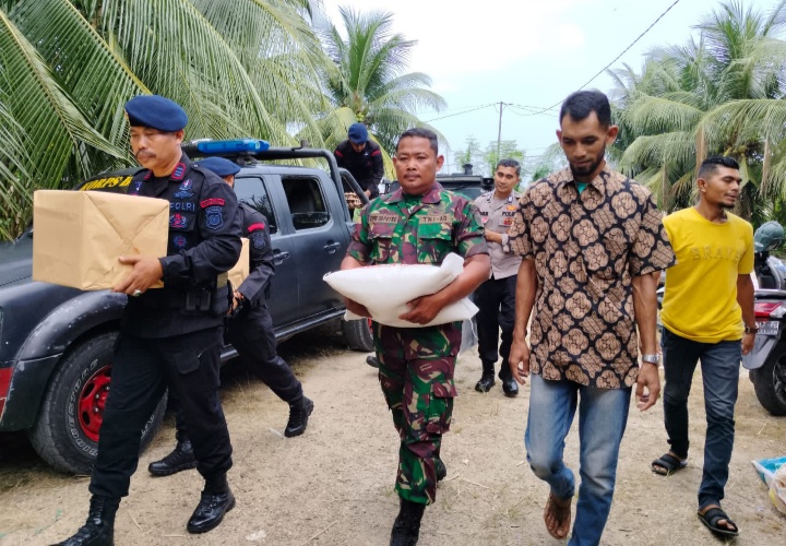Geuchik Gampong Alur Berawe Dampingi Tim Brimob Kompi 2 B Serahkan Bantuan Sembako Kepada Warganya.
